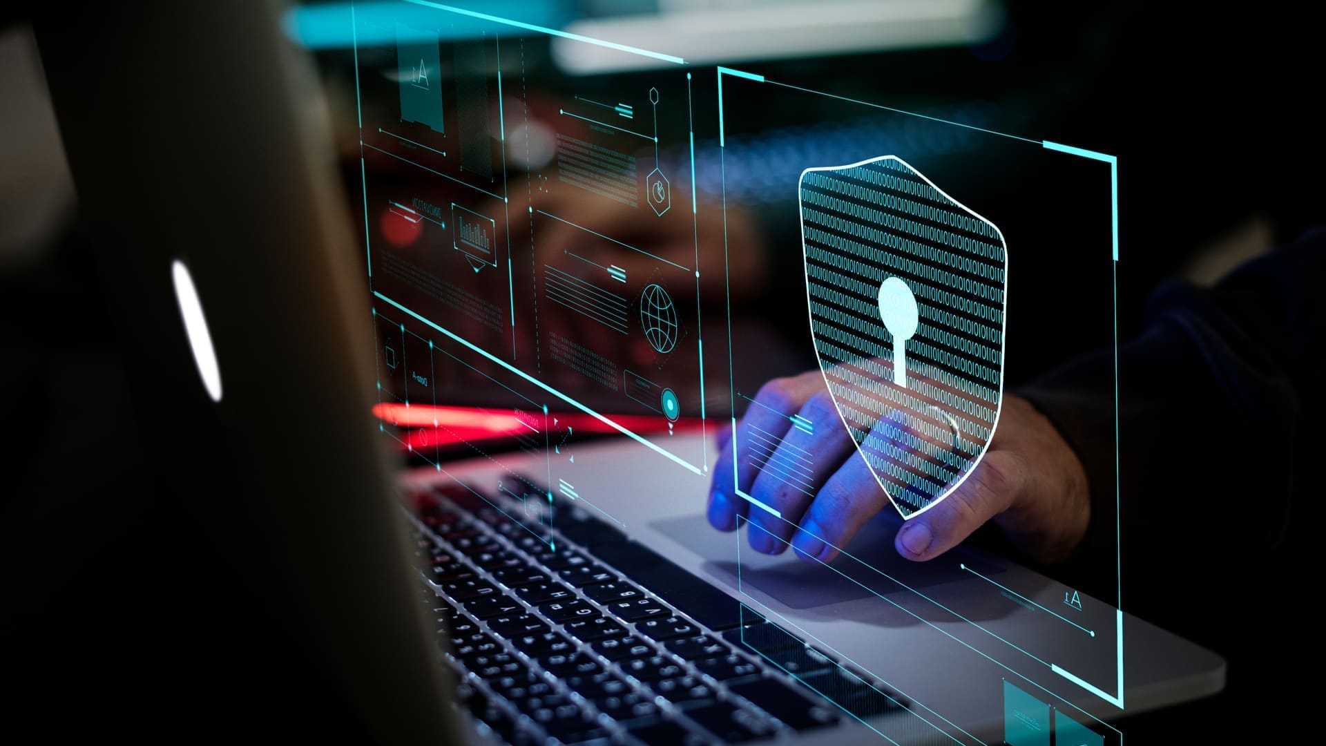 Hands typing on a laptop behind a translucent shield and padlock graphic