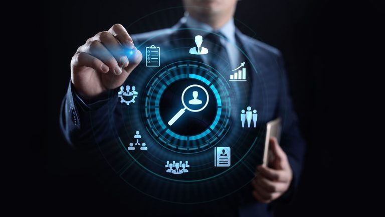 A person in a suit touching a glowing circular interface of business and analytics icons